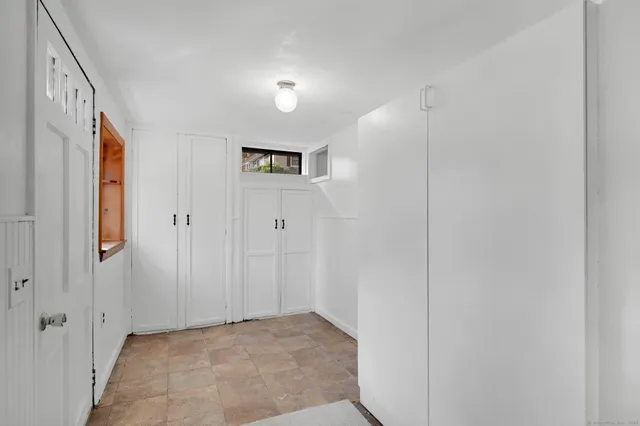 a front view of a house with a yard and large tree