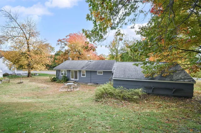 a backyard of a house with yard and outdoor seating