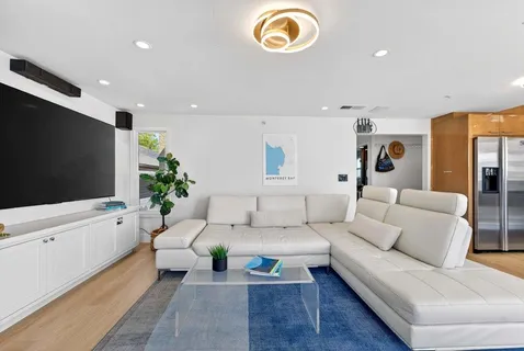 a living room with furniture a flat screen tv and a fireplace