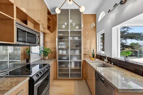 a kitchen with stainless steel appliances granite countertop a sink and a stove