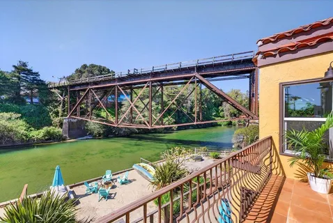 a view of a deck and a yard with large trees