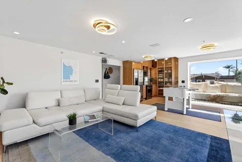 a living room with furniture and a view of kitchen chandelier