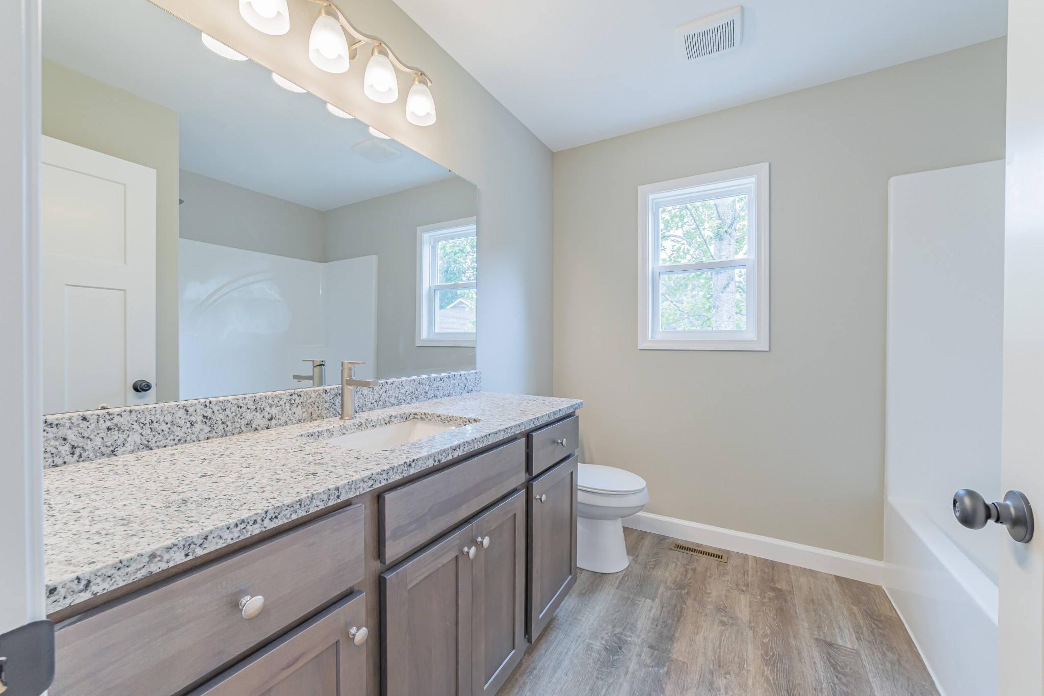 341 Wiseman Road Tullahoma, TN 37388 - Photo 16 of 21 a bathroom with a granite countertop sink a toilet and a mirror