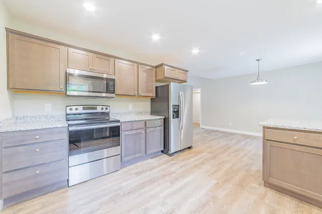 a kitchen with a refrigerator and a stove top oven