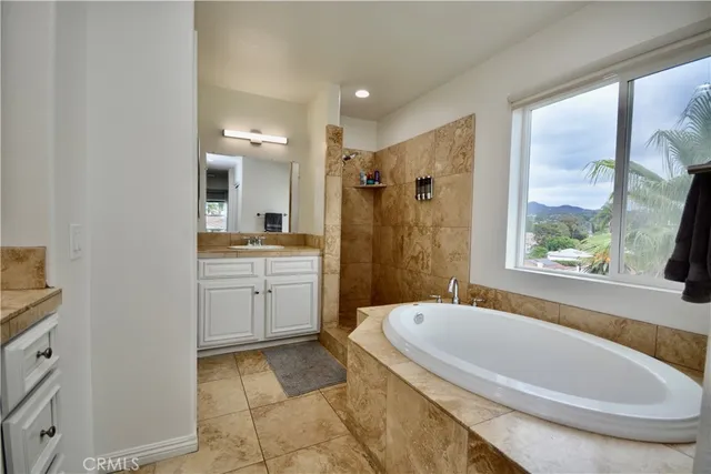 a bathroom with a granite countertop sink mirror bathtub and toilet