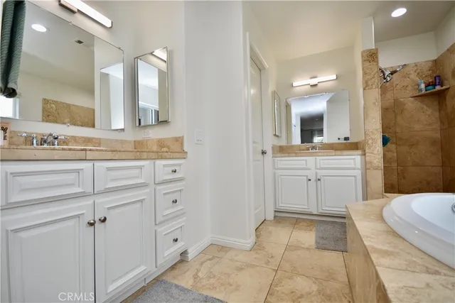 a spacious bathroom with a shower sink and mirror