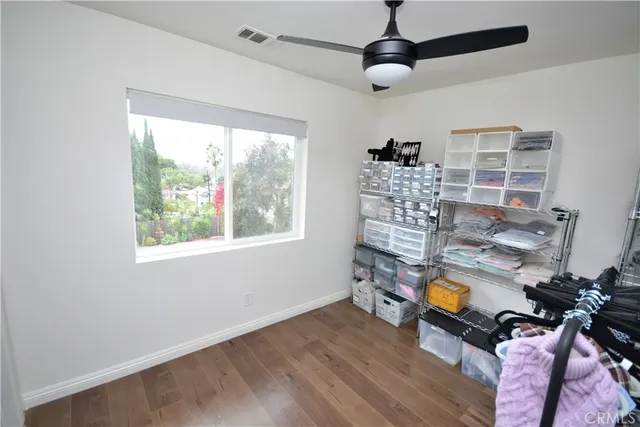 a room with chandelier fan and windows