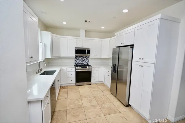 a kitchen with granite countertop a refrigerator and a sink