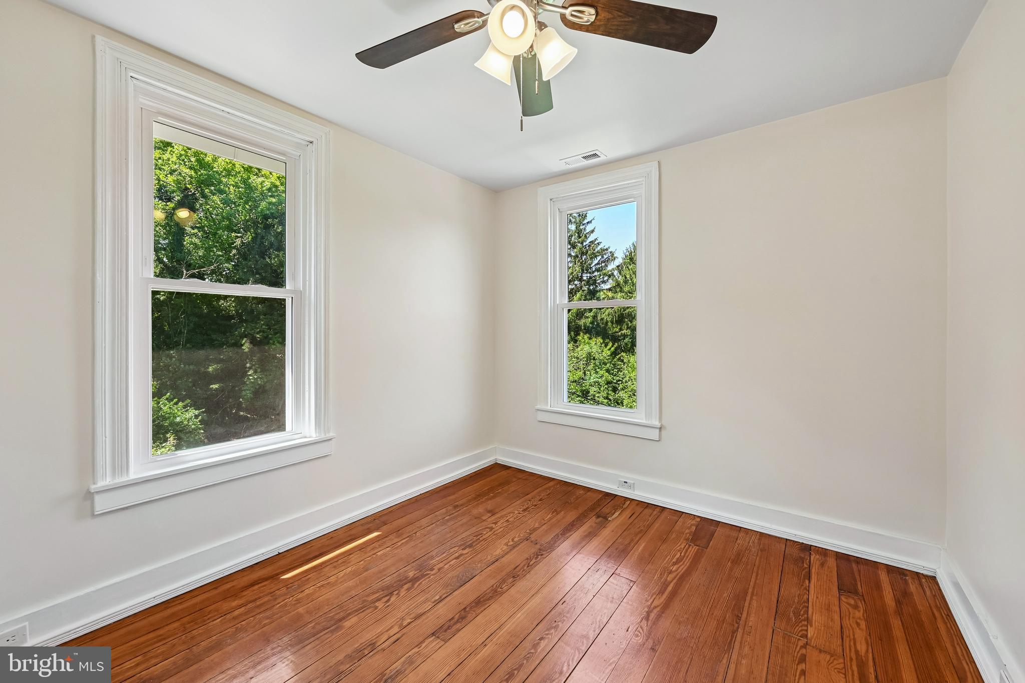 5702 Falls Road Baltimore, MD 21209 - Photo 27 of 49 an empty room with wooden floor chandelier and windows