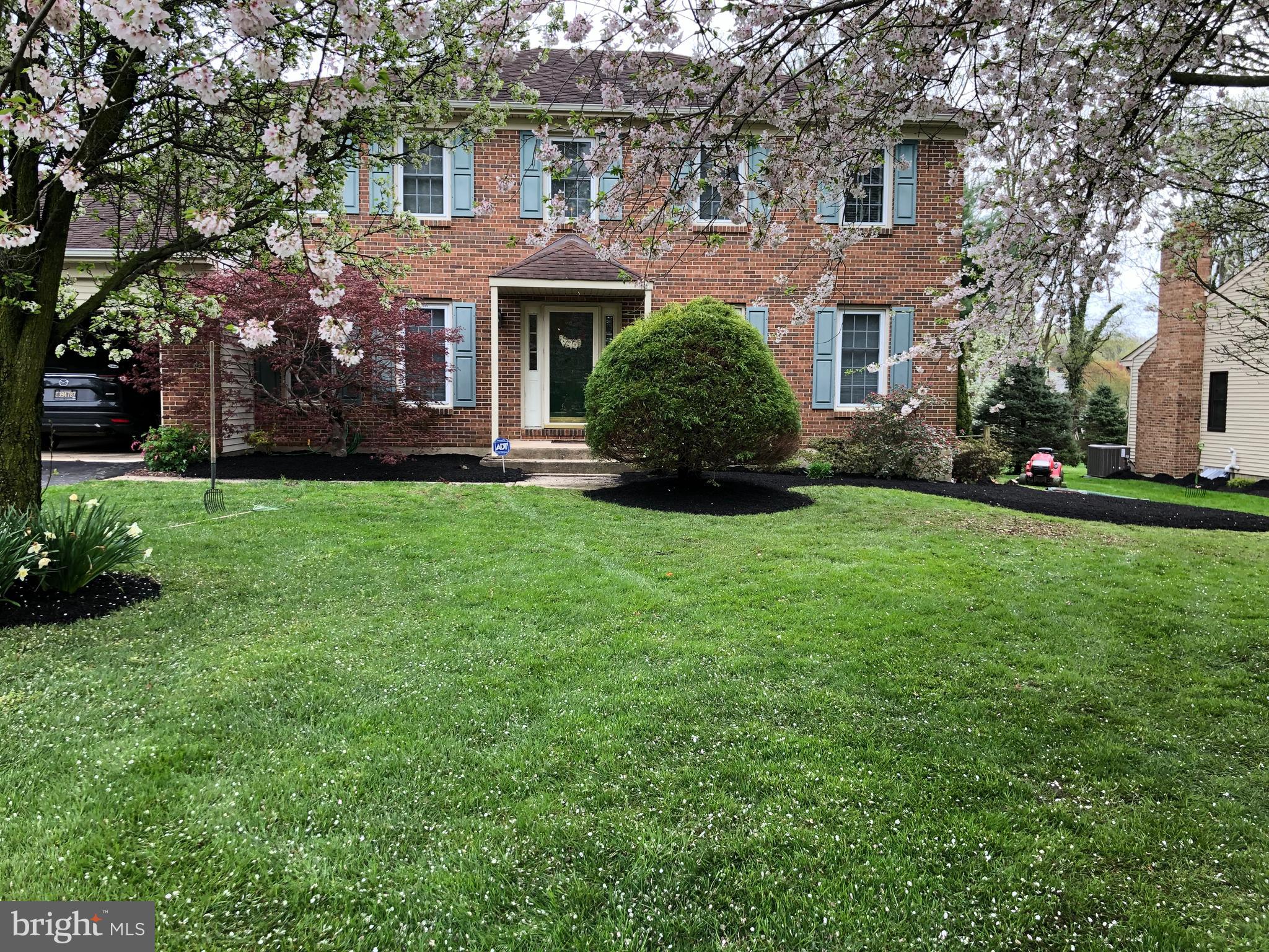a front view of a house with a yard and trees