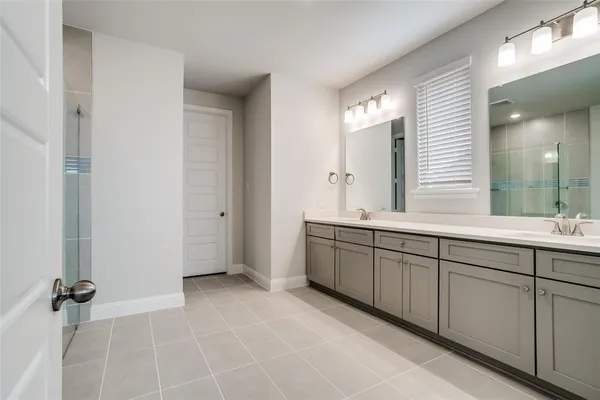 a spacious bathroom with a mirror a shower and a sink