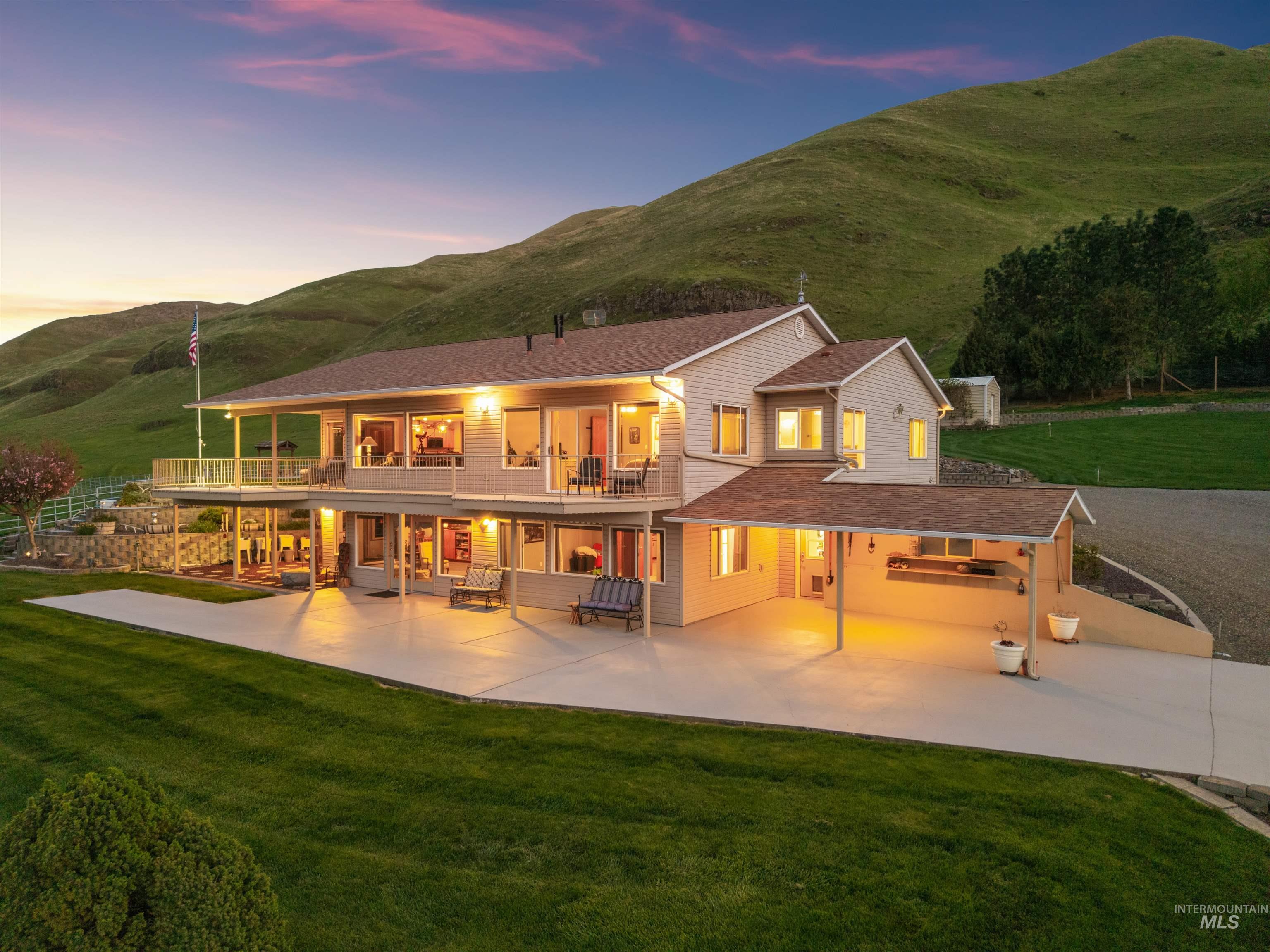 Back of property featuring a yard, a mountain view, a patio, and a balcony