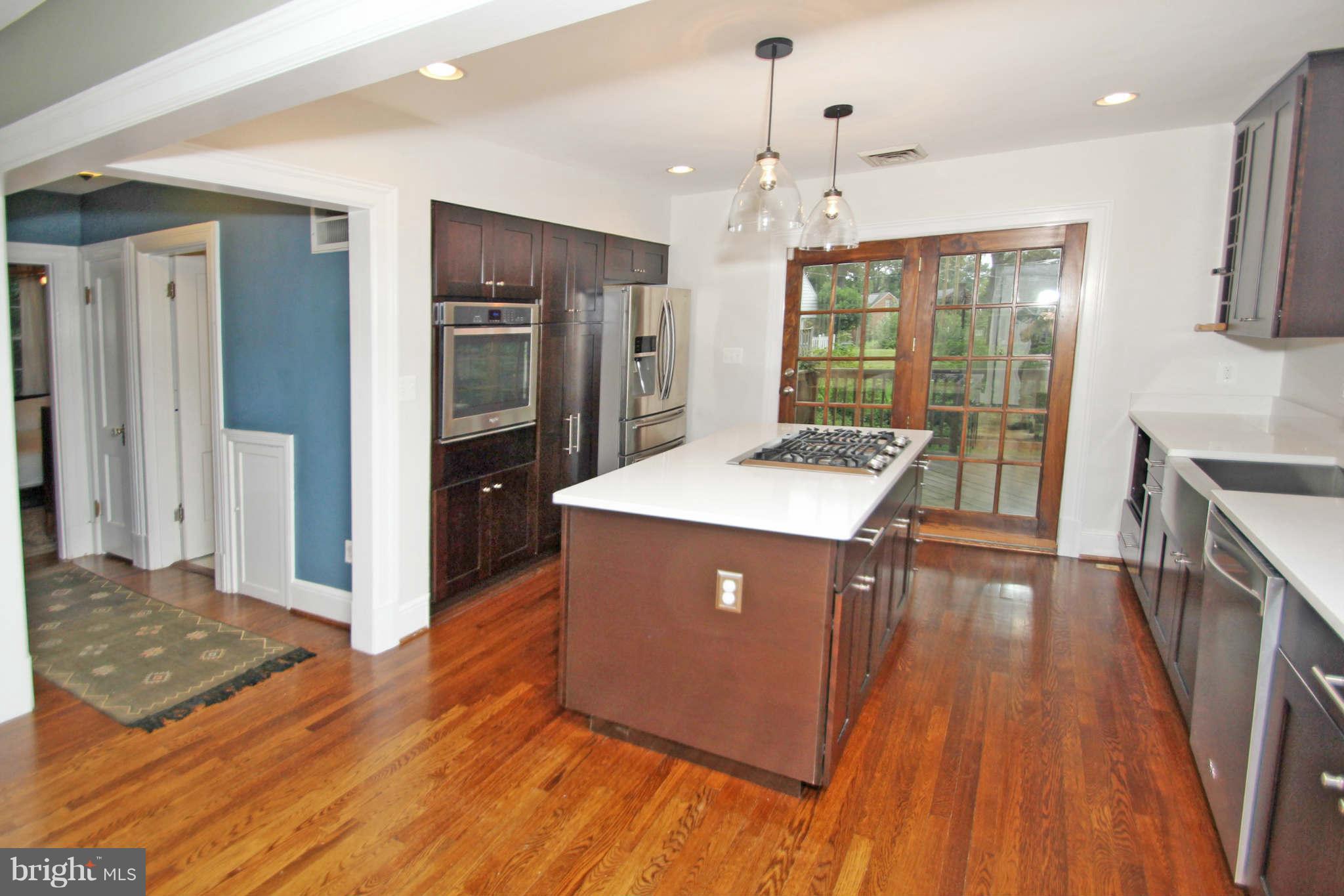 8 Sunnyside Road Silver Spring, MD 20910 - Photo 9 of 30 a kitchen with stainless steel appliances granite countertop a refrigerator a sink dishwasher a stove and white countertops with wooden floor