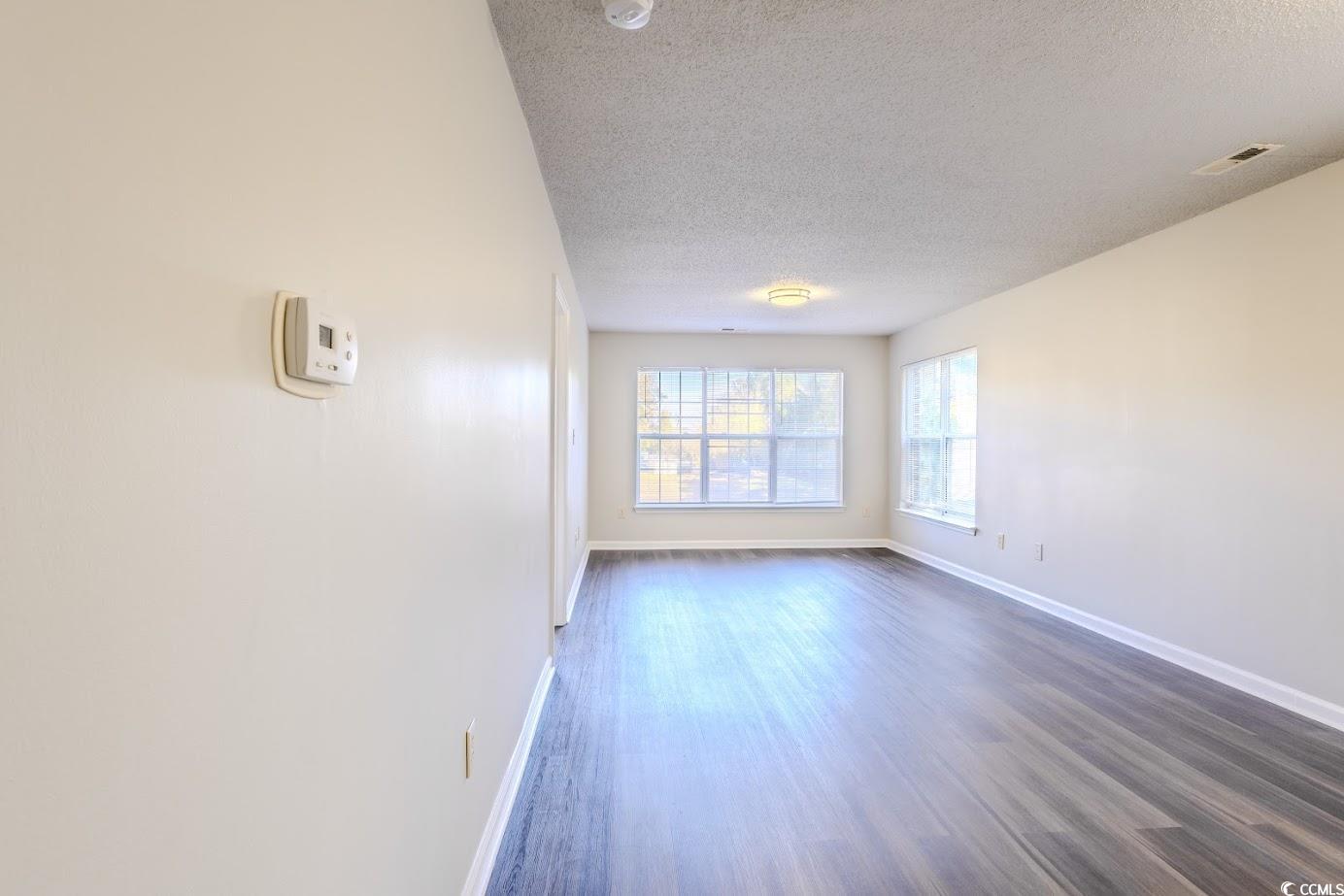 4246 Villas Drive, Unit 706 Little River, SC 29566 - Photo 11 of 20 Unfurnished room featuring a textured ceiling and wood finished floors