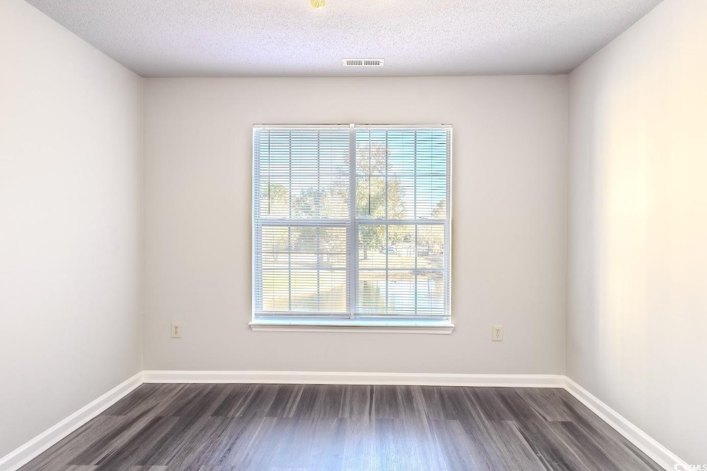 4246 Villas Drive, Unit 706 Little River, SC 29566 - Photo 14 of 20 Empty room with dark wood-style floors and a textured ceiling