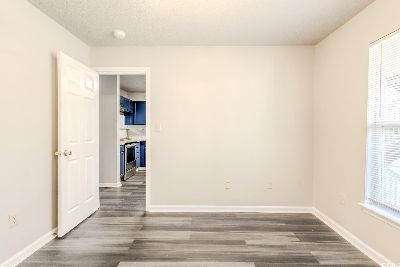 4246 Villas Drive, Unit 706 Little River, SC 29566 - Photo 18 of 20 Spare room featuring dark wood-style floors and baseboards