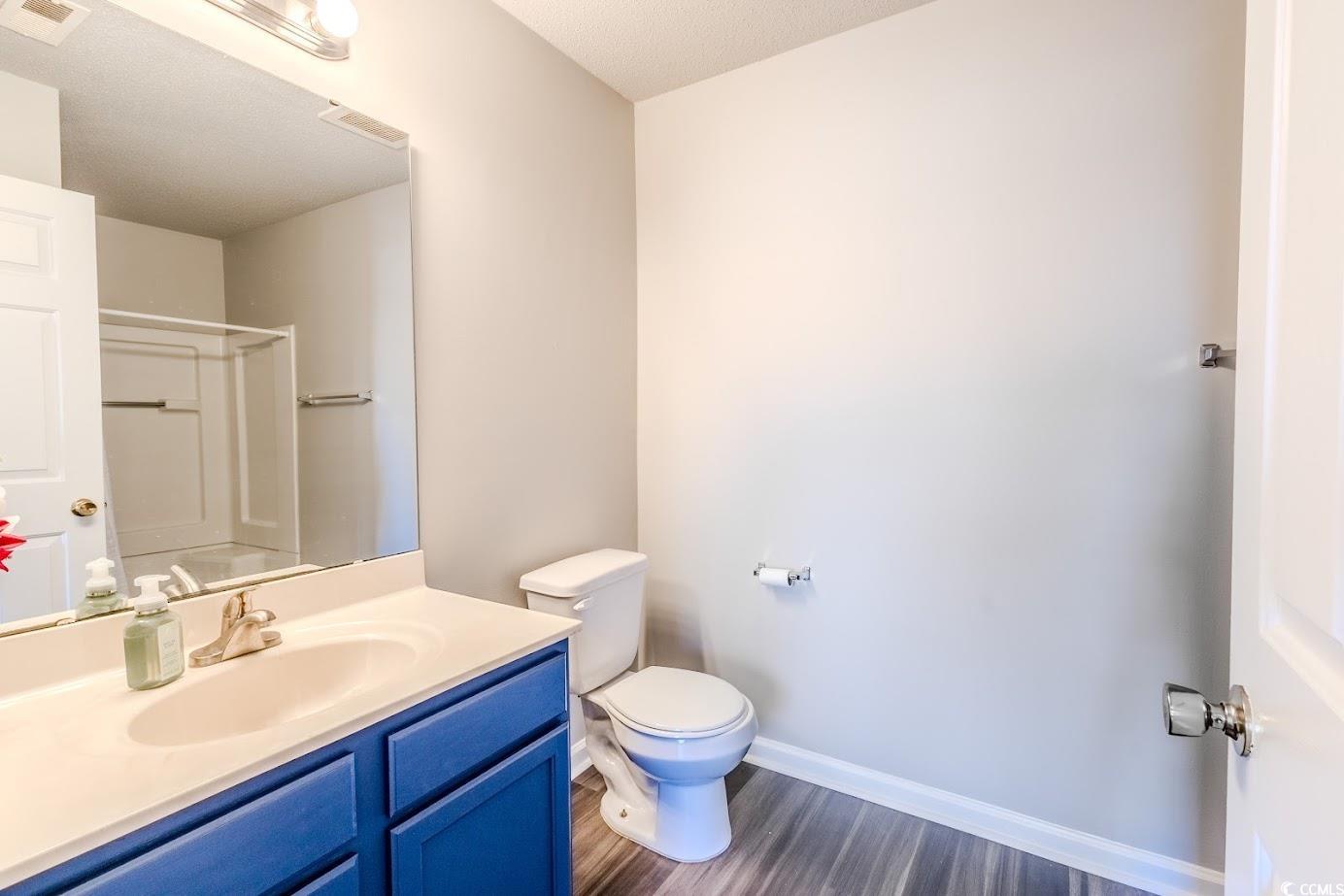 4246 Villas Drive, Unit 706 Little River, SC 29566 - Photo 20 of 20 Full bath featuring vanity, a shower, dark wood-style flooring, and a textured ceiling