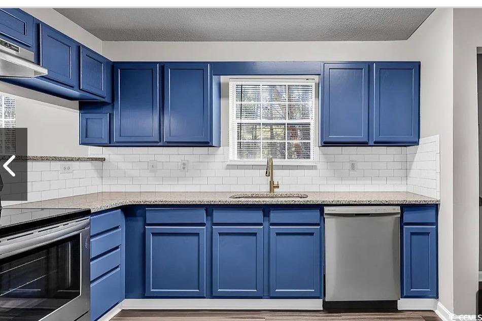 4246 Villas Drive, Unit 706 Little River, SC 29566 - Photo 5 of 20 Kitchen with blue cabinetry, appliances with stainless steel finishes, light stone countertops, tasteful backsplash, and a textured ceiling