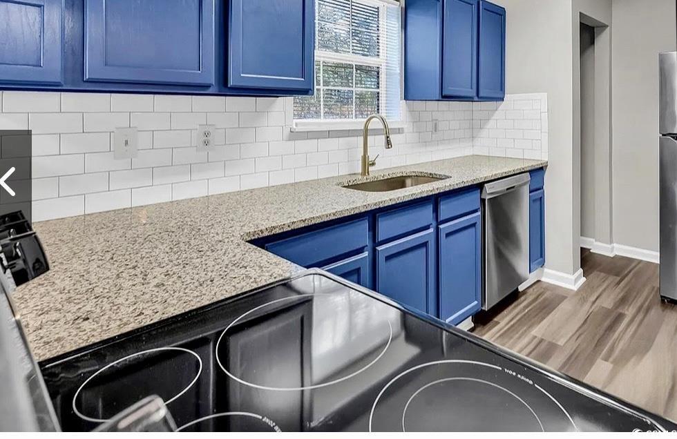 4246 Villas Drive, Unit 706 Little River, SC 29566 - Photo 9 of 20 Kitchen featuring blue cabinets, stainless steel appliances, dark wood-type flooring, light stone counters, and tasteful backsplash