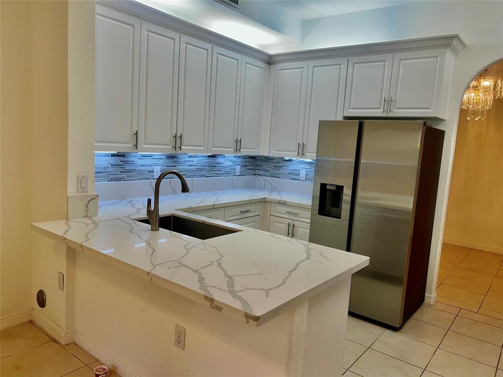 7932 Exeter Circle West, Unit 7932 Tamarac, FL 33321 - Photo 3 of 18 a kitchen with stainless steel appliances a refrigerator a sink a stove and cabinets