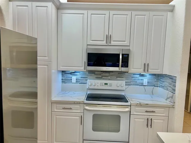a stove top oven sitting inside of a kitchen