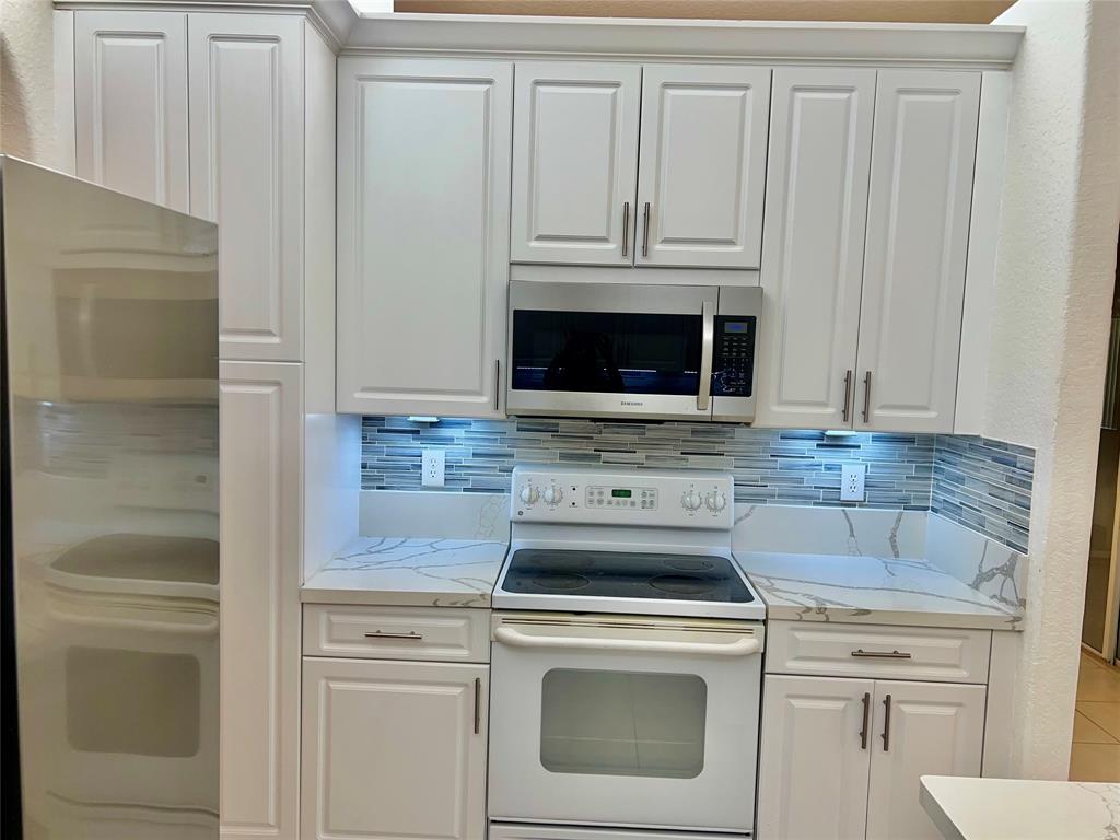 7932 Exeter Circle West, Unit 7932 Tamarac, FL 33321 - Photo 4 of 18 a stove top oven sitting inside of a kitchen