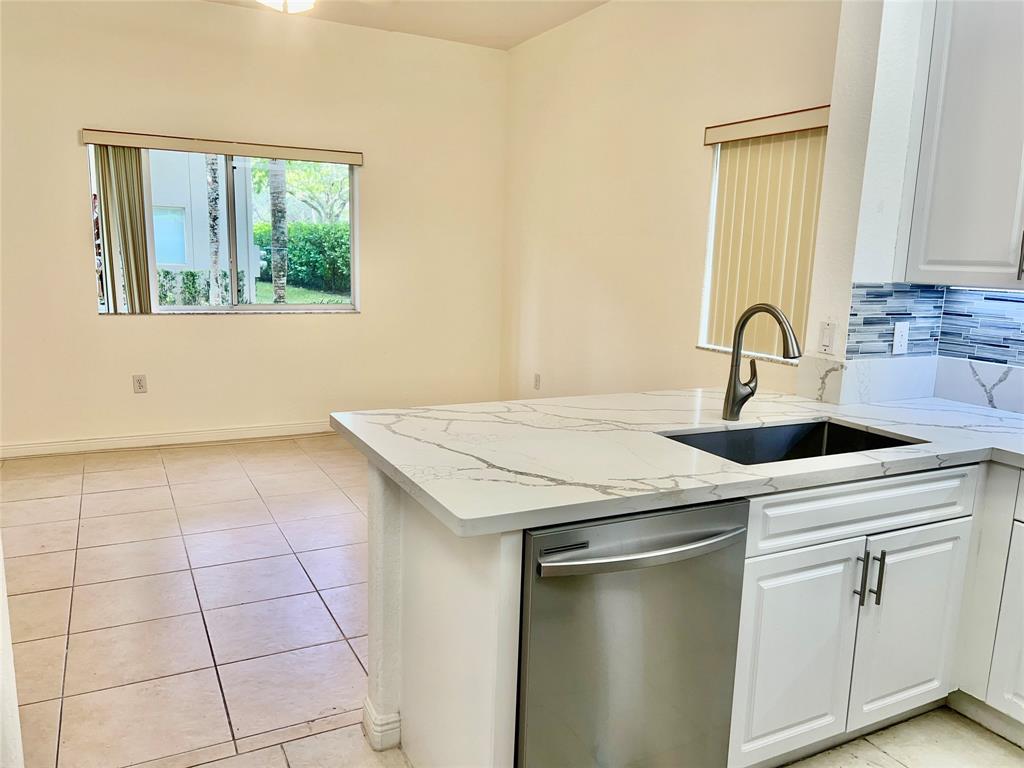 7932 Exeter Circle West, Unit 7932 Tamarac, FL 33321 - Photo 5 of 18 a kitchen with a sink a stove and cabinets