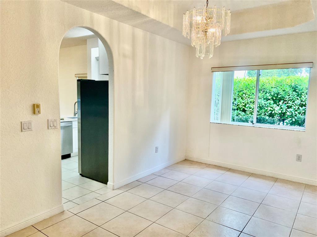 7932 Exeter Circle West, Unit 7932 Tamarac, FL 33321 - Photo 10 of 18 a view of a hallway with a chandelier fan and windows