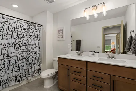 a bathroom with a double vanity sink toilet and a mirror