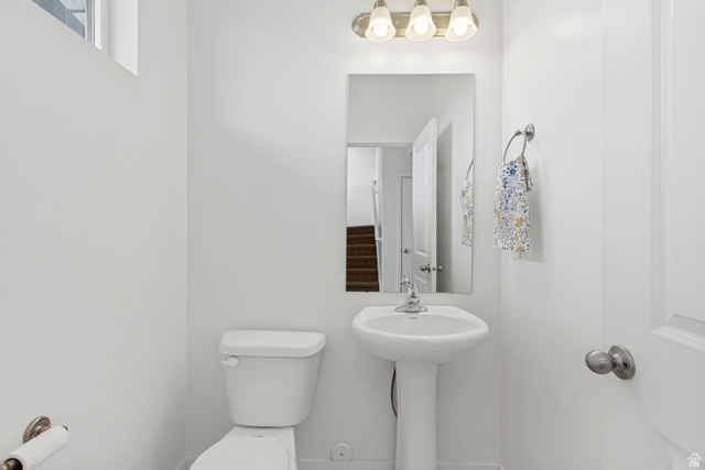 765 Crystal Crk Road American Fork, UT 84003 - Photo 20 of 27 Half bathroom on the first level by the garage with white pedestal sink with a chrome faucet