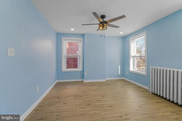 a view of a big room with wooden floor and windows