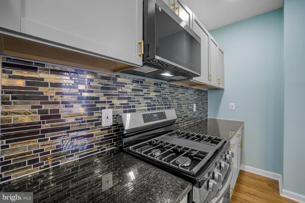 a stove top oven sitting inside of a kitchen