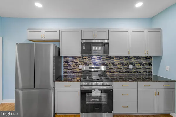 a kitchen with stainless steel appliances granite countertop a refrigerator and a stove top oven