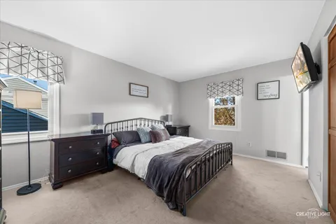 a bedroom with a bed and a flat tv screen on the dresser
