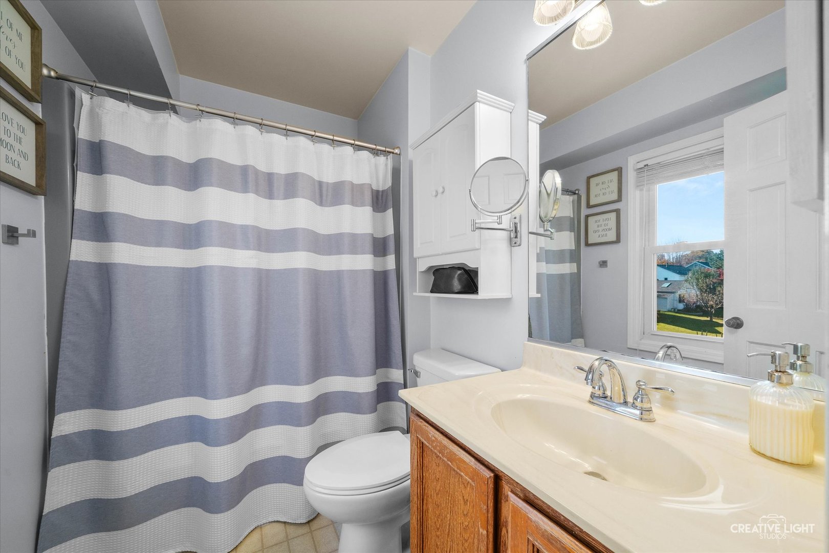 1348 Midway Avenue St. Charles, IL 60174 - Photo 13 of 23 a bathroom with a sink toilet a mirror and shower curtain