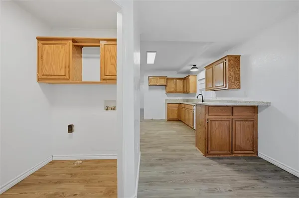 a view of a kitchen with wooden cabinets and a fireplace