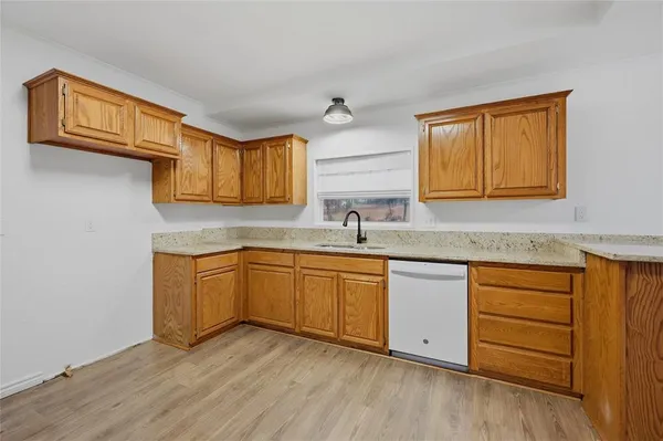a kitchen with stainless steel appliances granite countertop a sink cabinets and wooden floor
