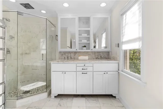 a bathroom with a granite countertop toilet a sink and shower