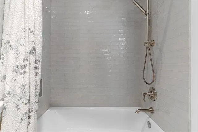 a view of a brick house with a small yard and wooden floor and fence