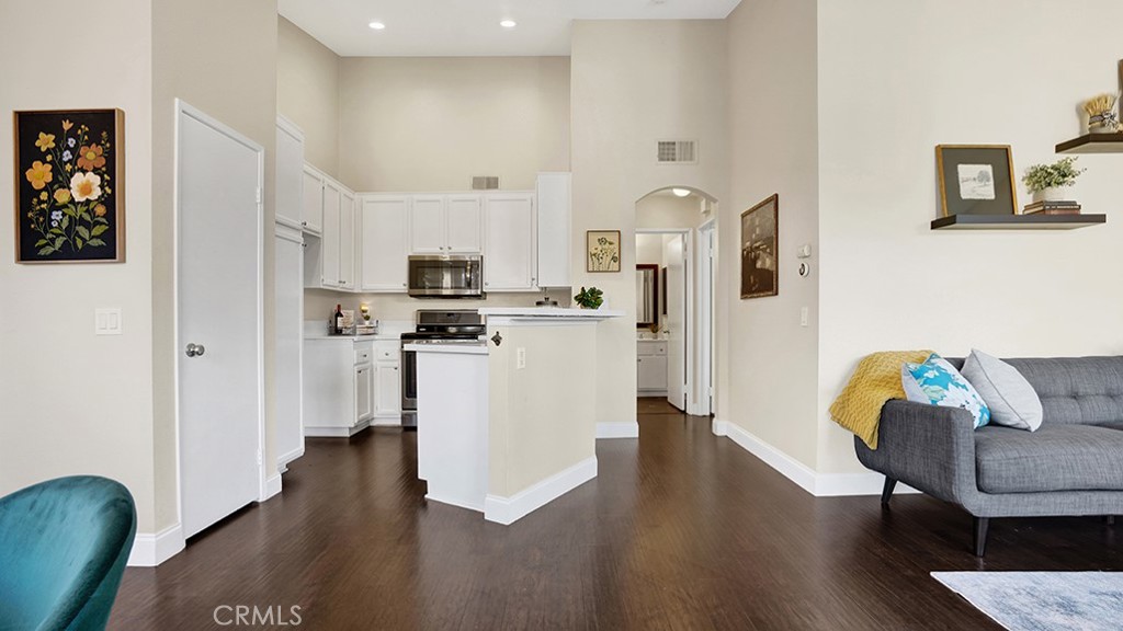 19431-57d Rue De Valore Lake Forest, CA 92610 - Photo 7 of 31 a kitchen with stainless steel appliances granite countertop a refrigerator a stove top oven a dining table and chairs with wooden floor