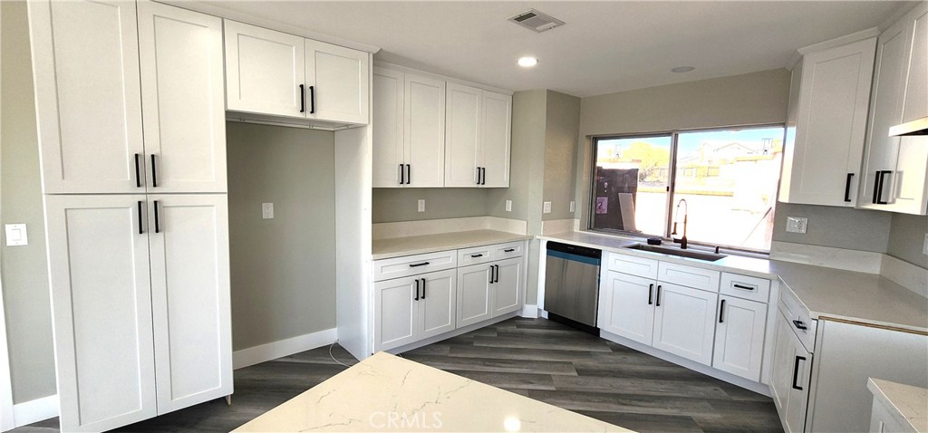 16257 St Timothy Road Apple Valley, CA 92307 - Photo 12 of 28 a kitchen with granite countertop white cabinets and white appliances