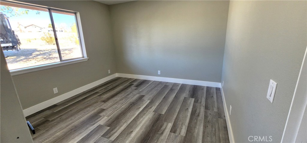 16257 St Timothy Road Apple Valley, CA 92307 - Photo 18 of 28 a view of a room with wooden floor and window