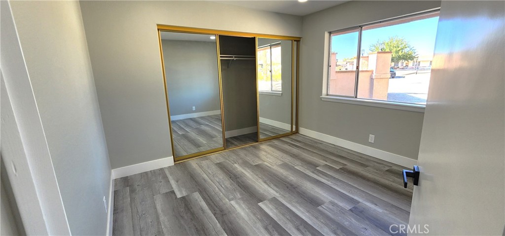 16257 St Timothy Road Apple Valley, CA 92307 - Photo 19 of 28 a view of an empty room with wooden floor and a window
