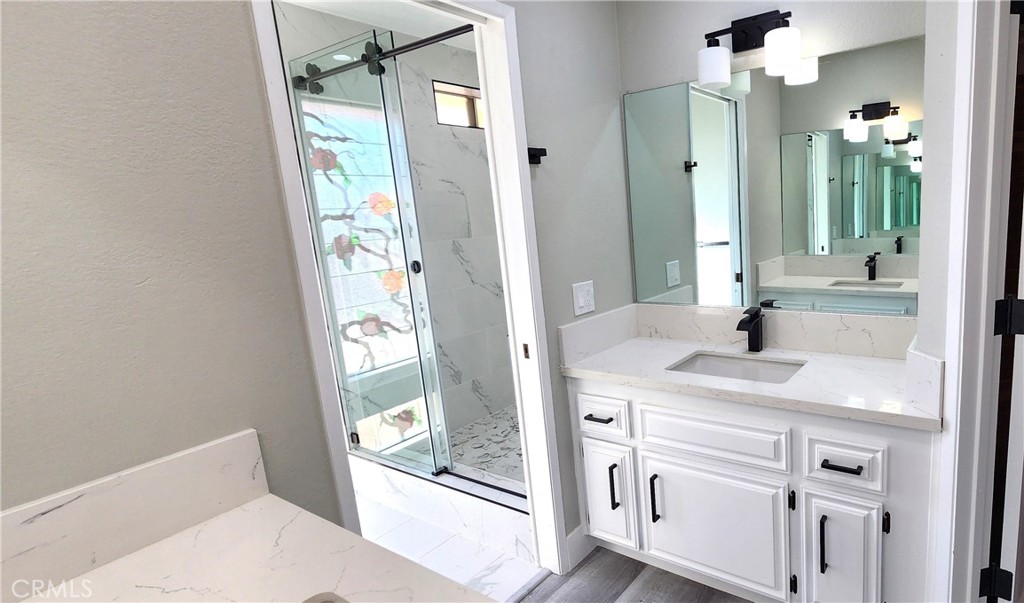 16257 St Timothy Road Apple Valley, CA 92307 - Photo 24 of 28 a en suite bathroom with a granite countertop sink and a mirror