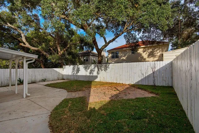a view of backyard with wooden fence