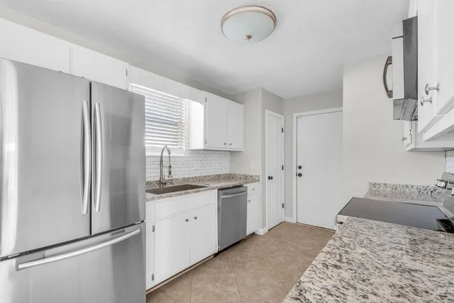 a kitchen with a sink stove and refrigerator