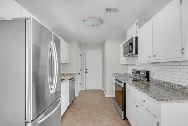 a kitchen with stainless steel appliances granite countertop a refrigerator and a sink
