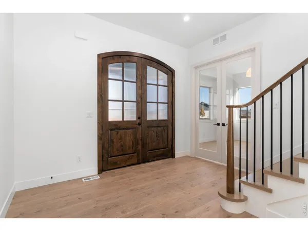 a view of a hallway with wooden floor and staircase