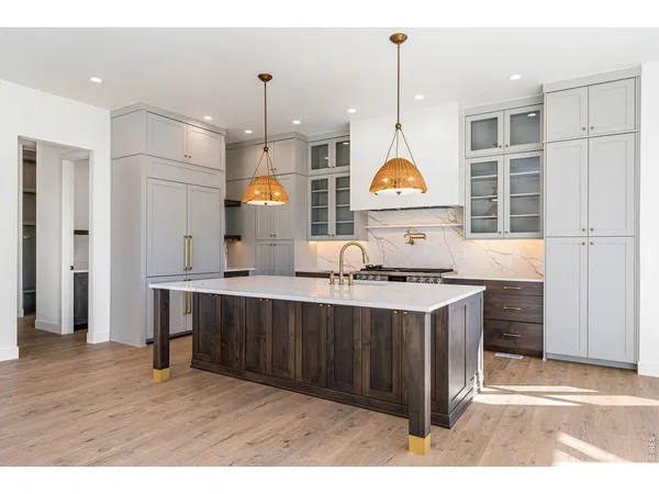 a kitchen with stainless steel appliances granite countertop a sink a stove and a wooden floors