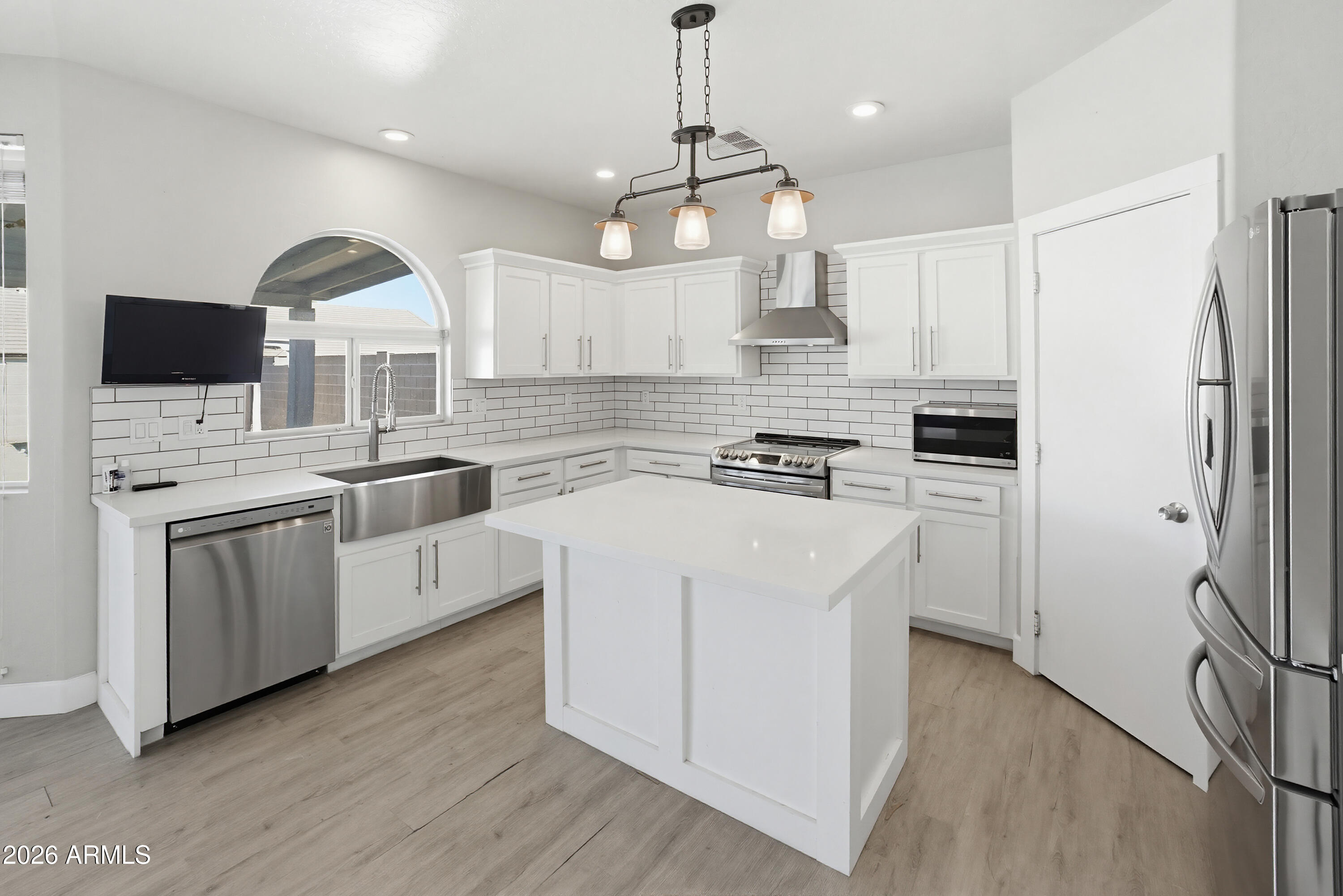 3818 West Carson Road Phoenix, AZ 85041 - Photo 13 of 41 a kitchen with white cabinets and stainless steel appliances